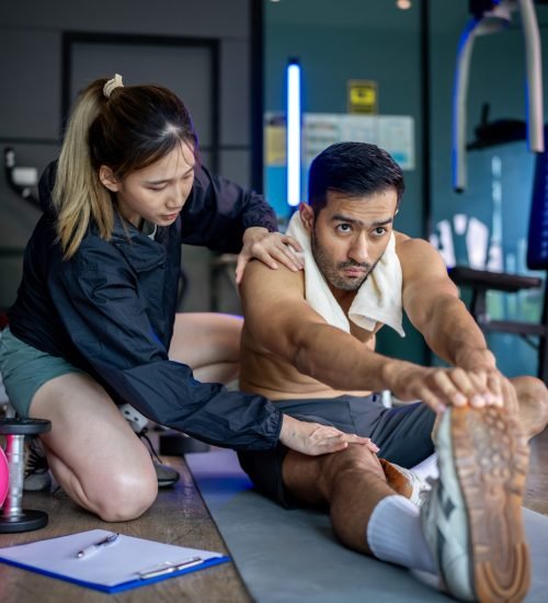 Asian man and woman working out, one is a trainer, the other is an exerciser